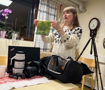 Valokuvaajan varustelaukku on täynnä tavaraa, jota tarvitsee kuvauspaikoilla. Tässä Helena Karhu esittelee linssien puhdistukseen tarvittavaa liinaa. 