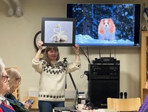 Kameralaukun painon lähimmäksi arvanneelle valokuvaaja Helena Karhu lahjoitti valokuvaamansa joutsenkuvan. Kameralaukku painoi noin 10 kg. Taustalla Helenan ottamassa kuvassa rakas Ekku-koira, valokuvaajan kaveri. 